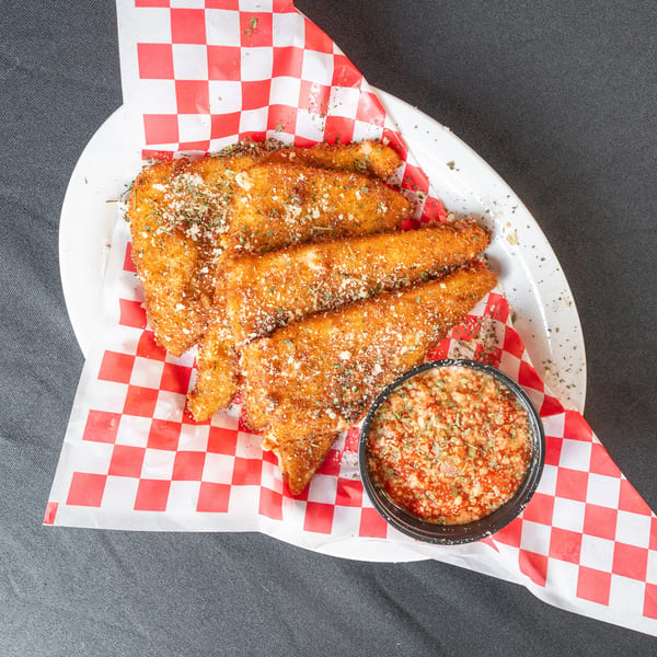 Golden-brown fried mozzarella sticks dusted with herbs and cheese, served with a side of marinara sauce.